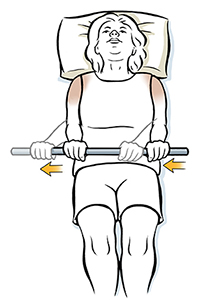 Woman lying on back holding wand doing external rotation shoulder exercise.