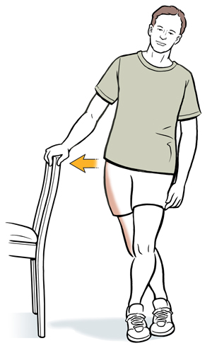 Man holding chair with one hand, one leg crossed behind the other. Arrow shows him leaning hip towards chair to stretch iliotibial band.
