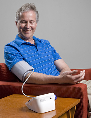 Hombre midiéndose la presión arterial en su hogar.